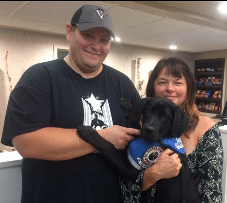 chair_mike_lundy_with_united_by_trauma_founder_nicole_taylor_and_a_new_addition_to_the_service_dog_family.png