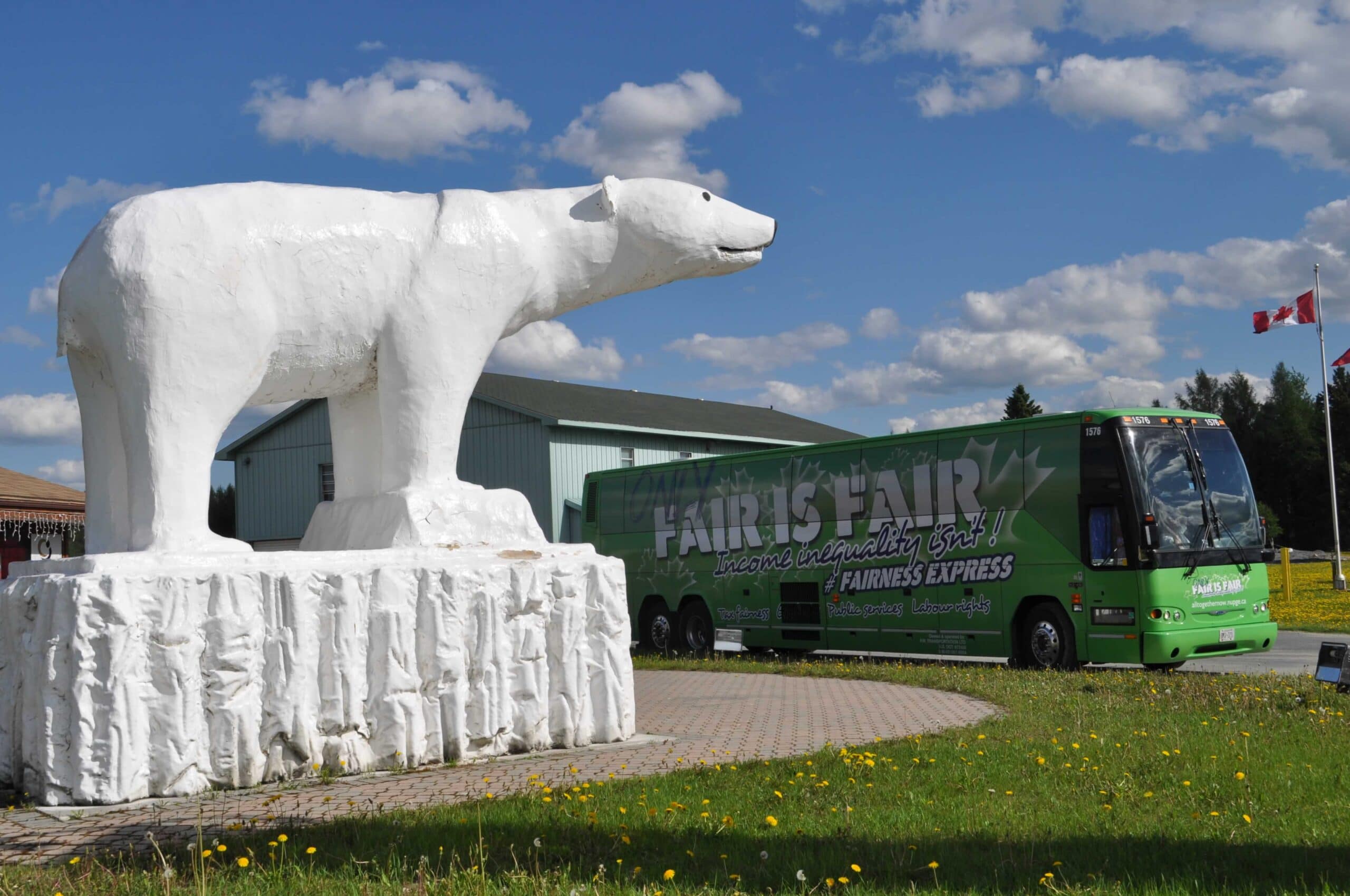 Bus that says: Only Fair is Fair, income inequality isn't! Large polar bear statue in the park