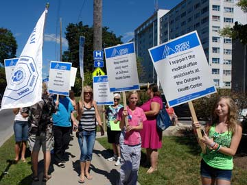 OPSEU members holding picket signs outside Oshawa Health Centre.