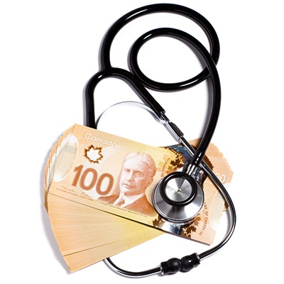 Stethoscope on stack of Canadian bank notes
