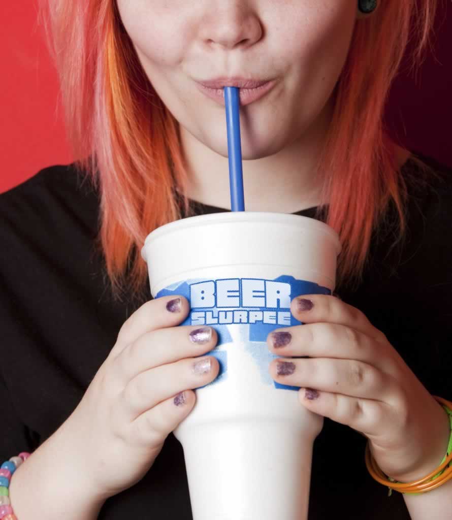 Girl taking a drink out of a beer slurpie glass